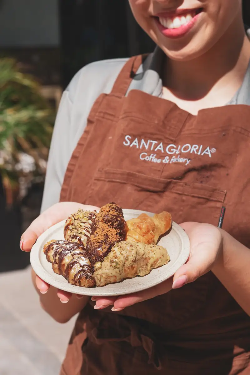 Colaboradora de Santagloria sosteniendo un plato de bollería artesanal